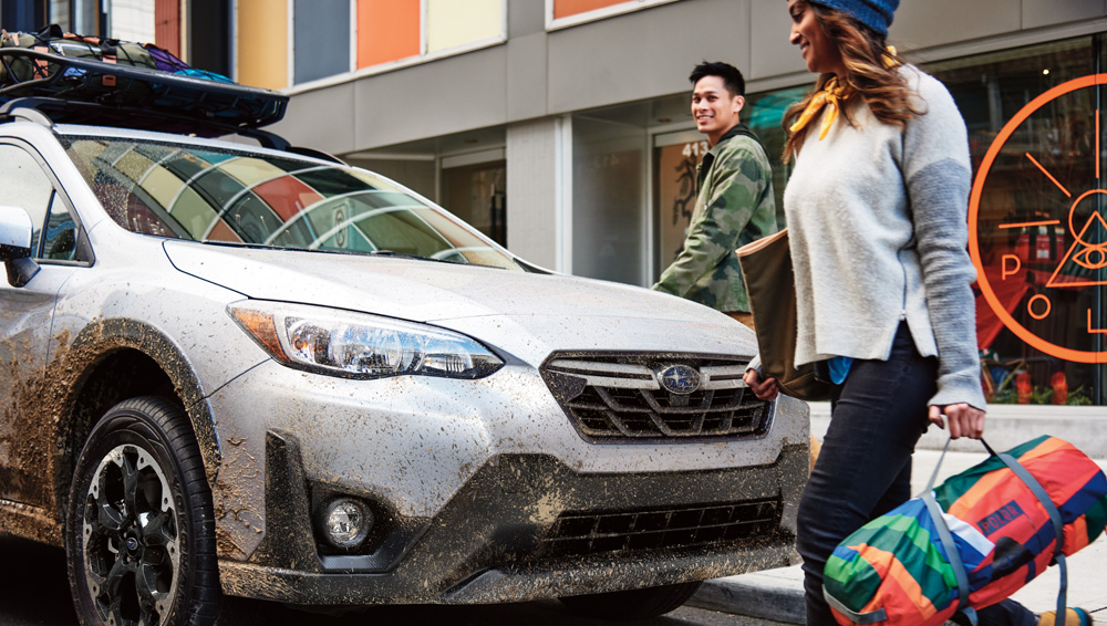 A Young Couple Standing In Front Of 2021 SUBARU Crosstrek