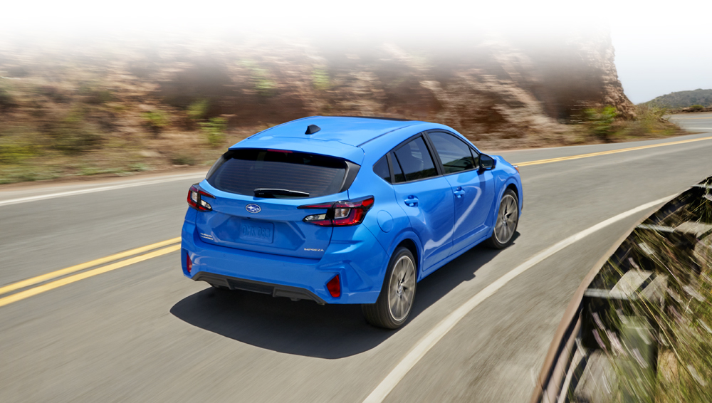 Rear shot of Impreza driving along a curvy mountain road.