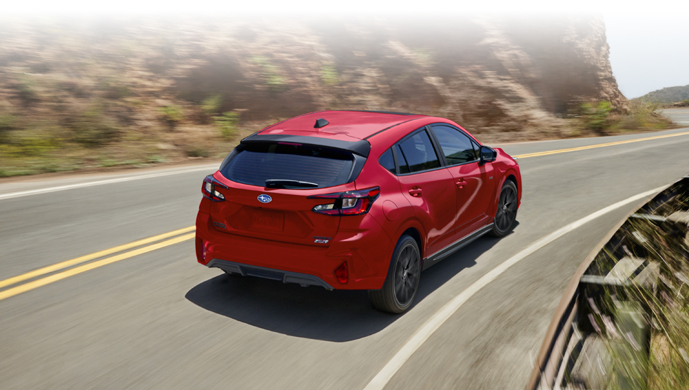 Rear shot of Impreza driving along a curvy mountain road.