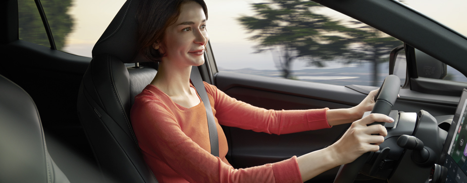 A man driving a car, hands positioned on the steering wheel, concentrating on the road ahead