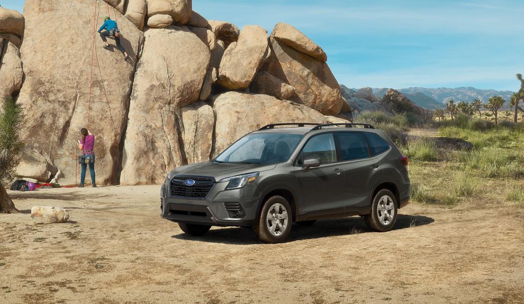 Forester 2023 garée devant une paroi rocheuse avec un couple de grimpeurs.