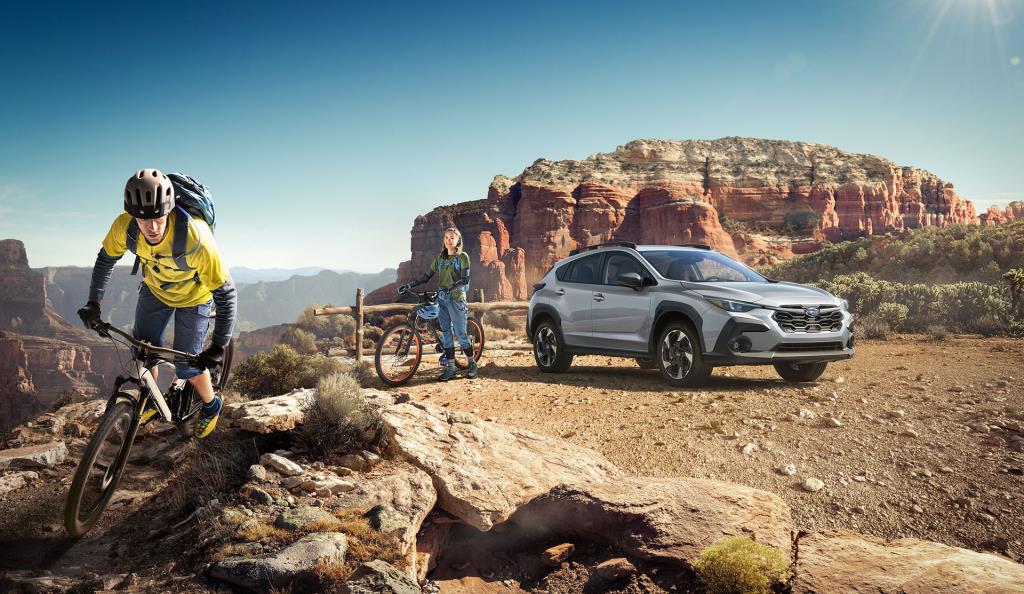 Crosstrek 2024 stationnée dans la nature, couple partant à vélo.