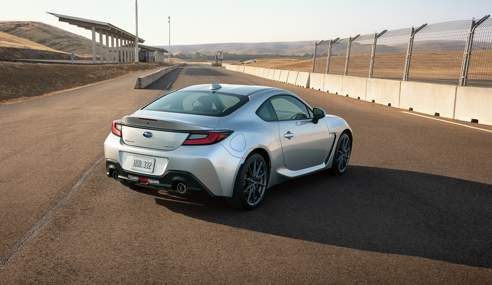 Rear view of the 2024 BRZ stopped by the fence at the race track.