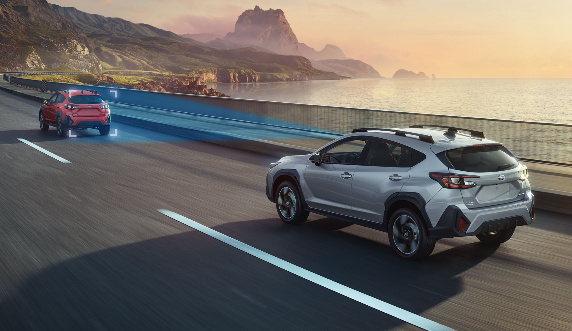 Rear shot of the 2024 Crosstrek driving along coastal road using EyeSight adaptive cruise control.