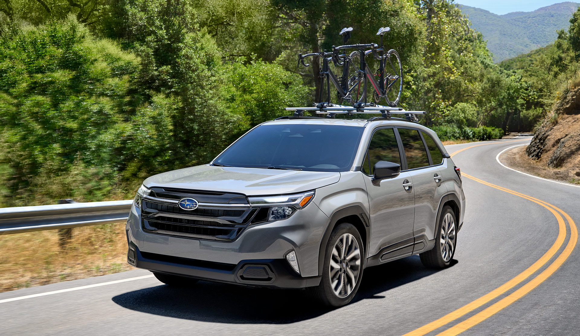 2025 Subaru Forester driving on a rural road.
