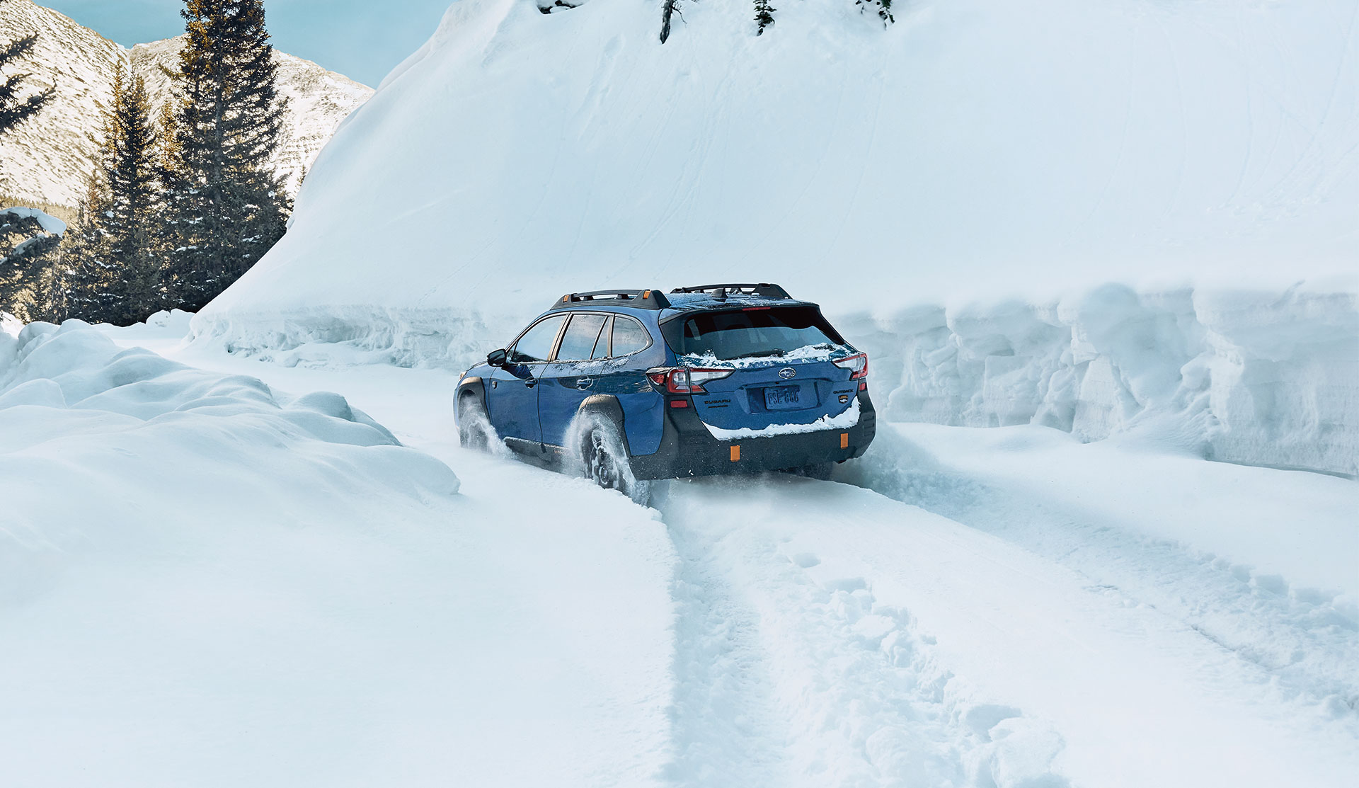 Rear shot of 2024 Outback Wilderness driving in deep snow