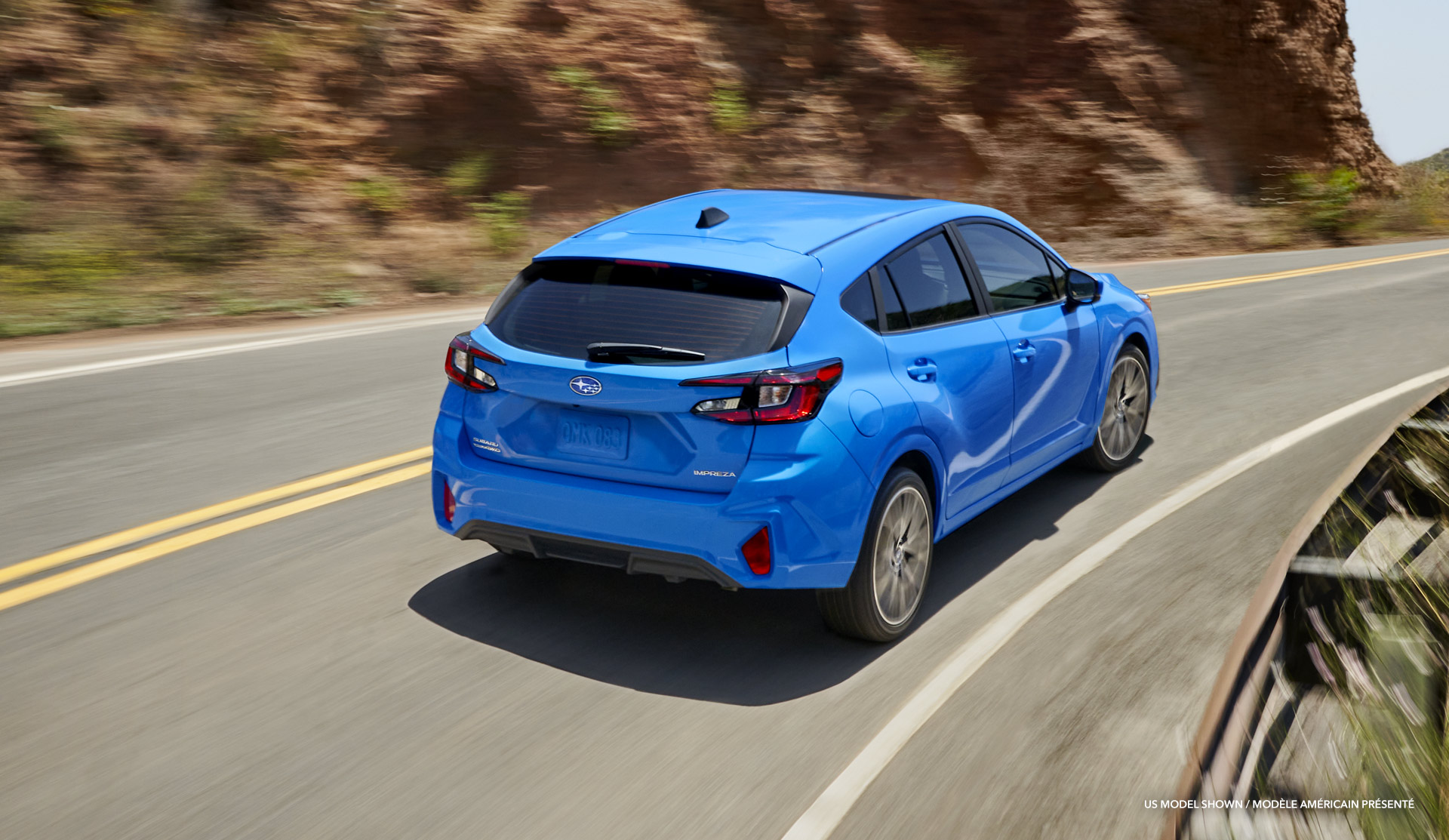 Rear shot of the 2024 Impreza driving on a canyon road.