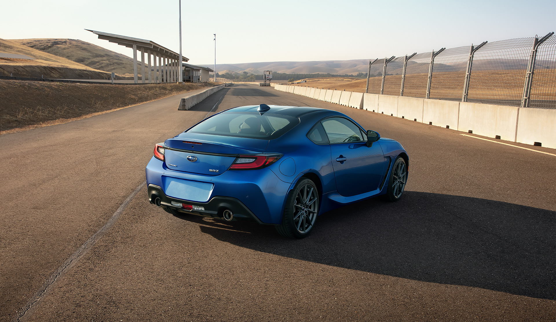 Vue arrière de la BRZ 2025 garée près de la clôture d’une piste de course.