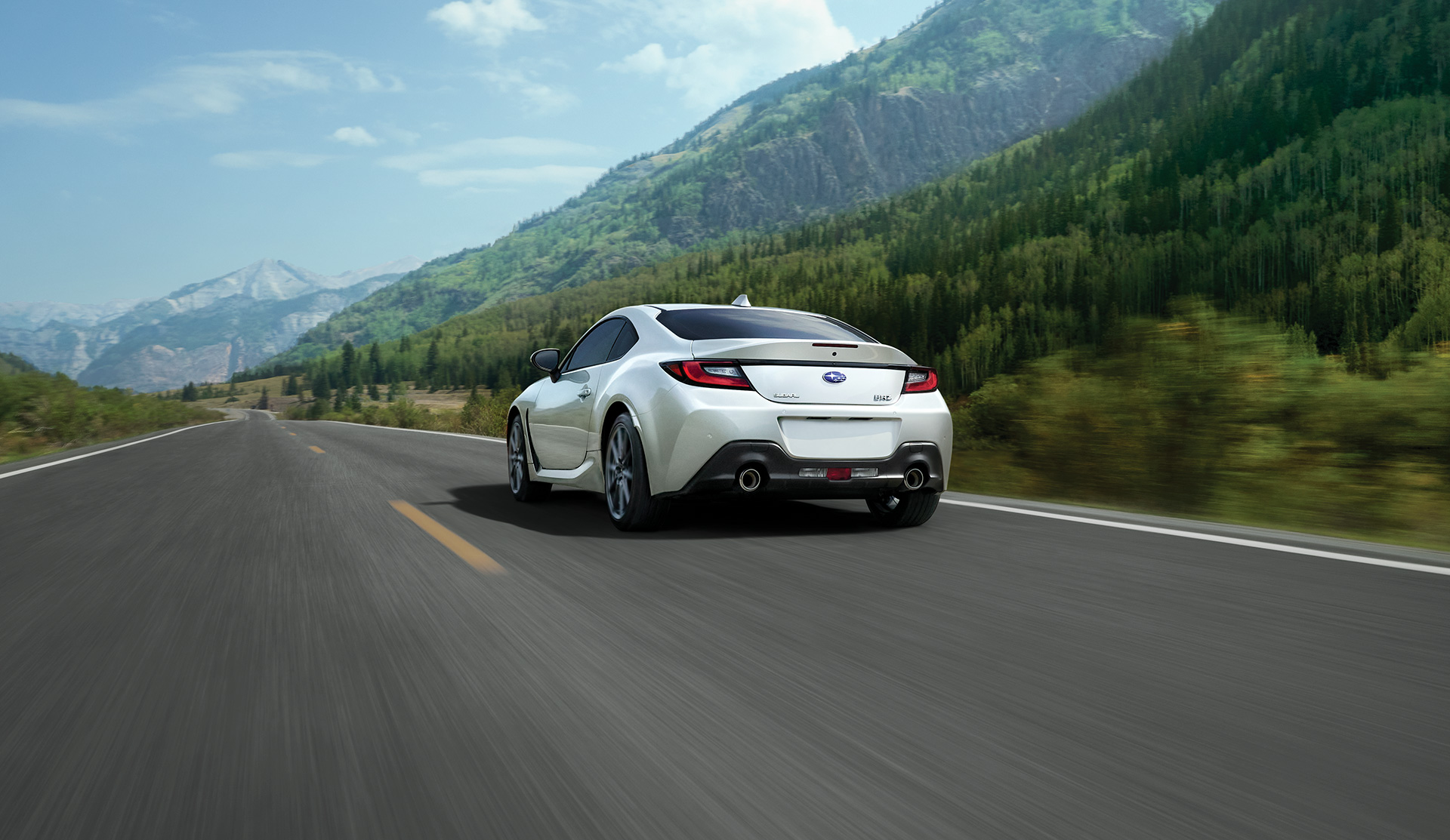 Vue arrière de la BRZ Sport-tech 2025 roulant sur une route de campagne.