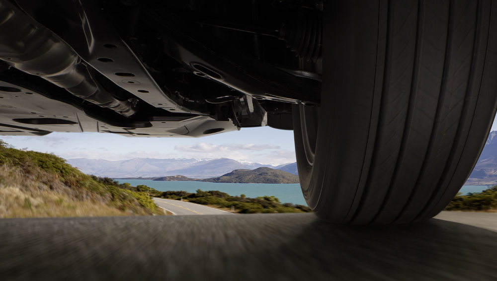 Closeup beneath the 2024 Outback and the road showcasing the generous ground clearance.
