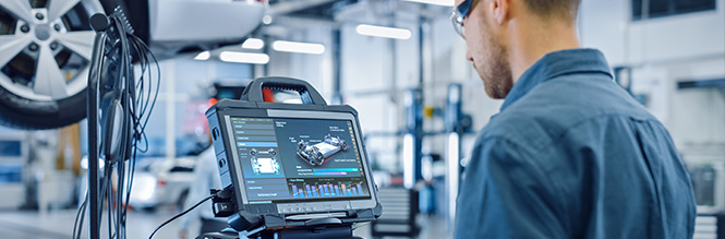: A technician conducting vehicle diagnostics via a digital screen.