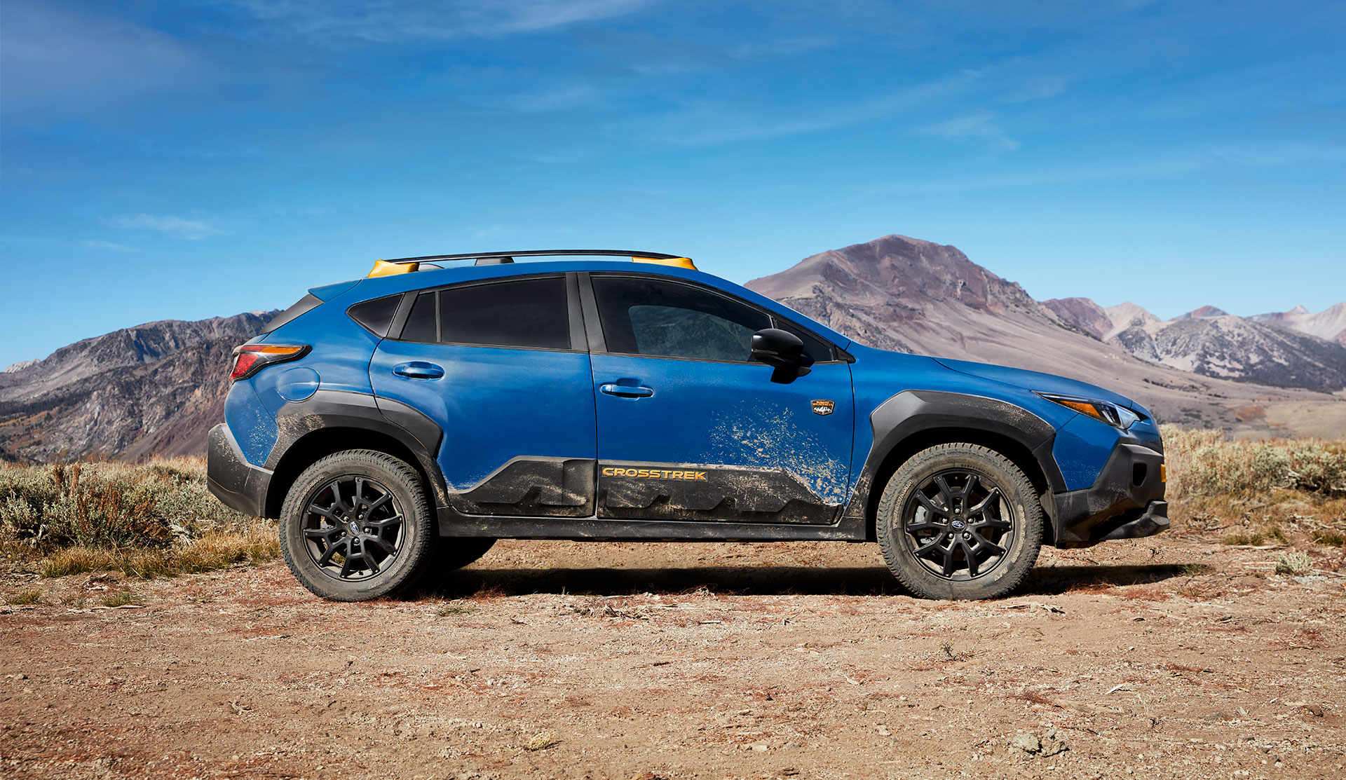 Side shot of 2024 Crosstrek Wilderness parked on dusty trail.