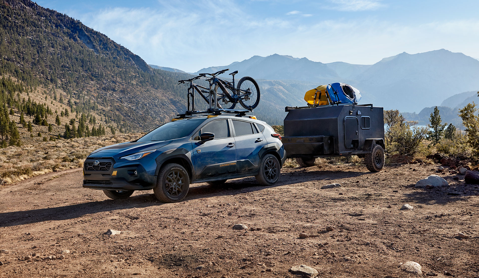 Shot of Parked Crosstrek Wilderness 2024 towing a small camper.