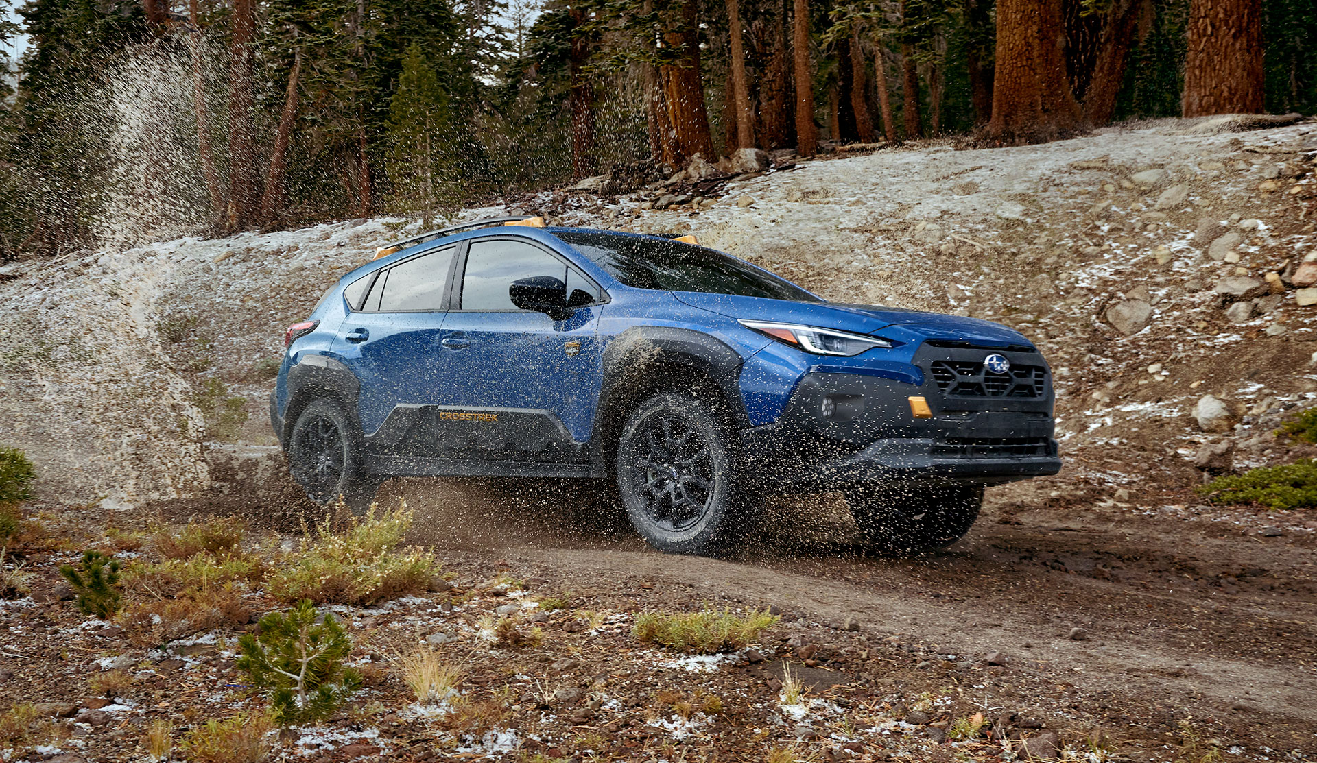 Front shot of 2025 Crosstrek Wilderness moving fast along offroad trail.