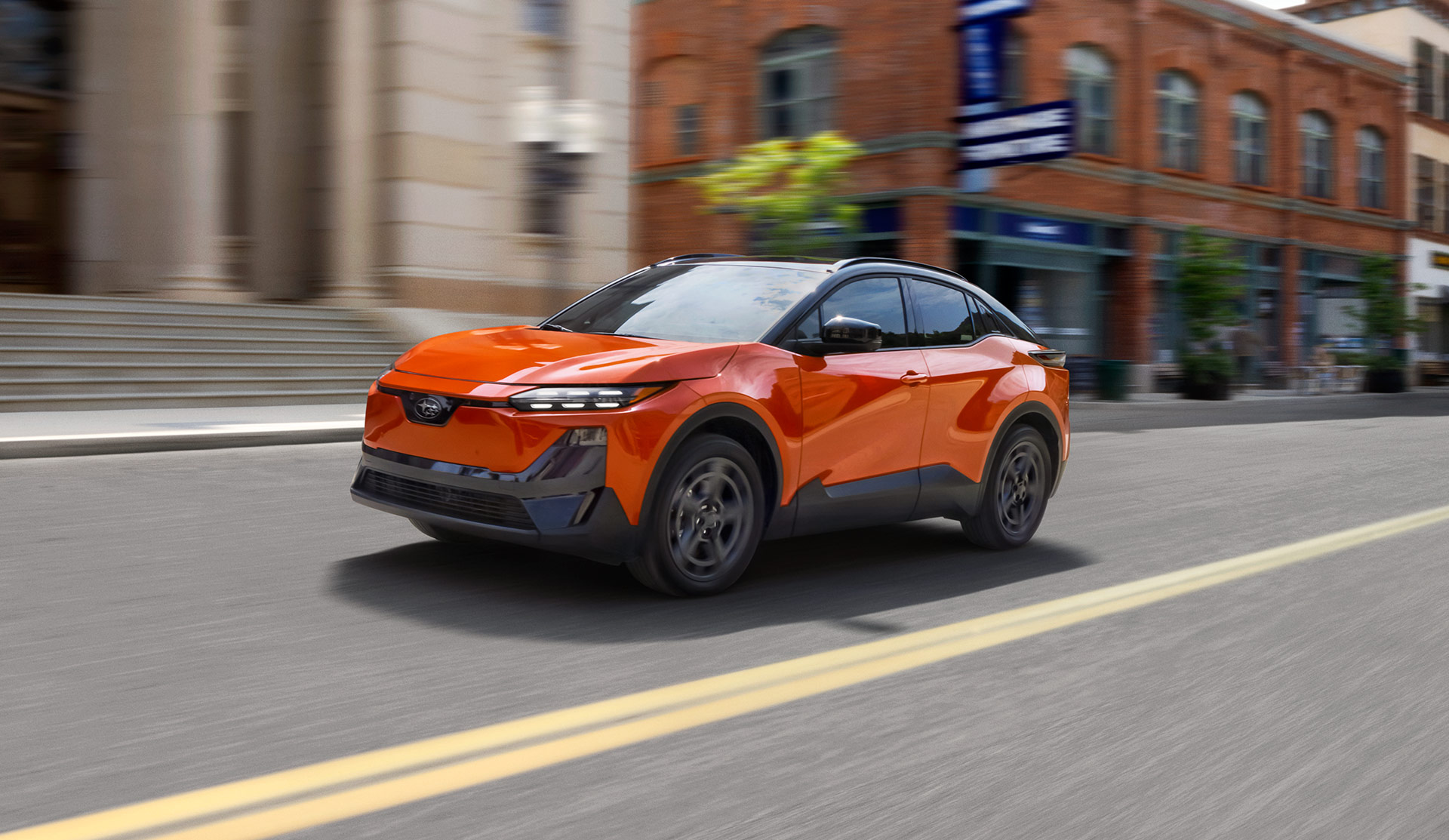 2026 Subaru Uncharted navigates a city street, highlighting its modern style amidst urban architecture.