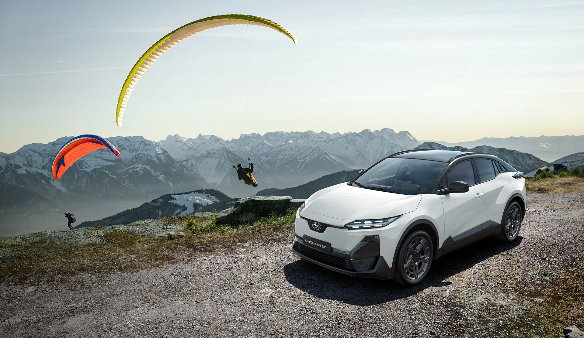 2026 Uncharted parked on a mountain top, while paragliders taking off.